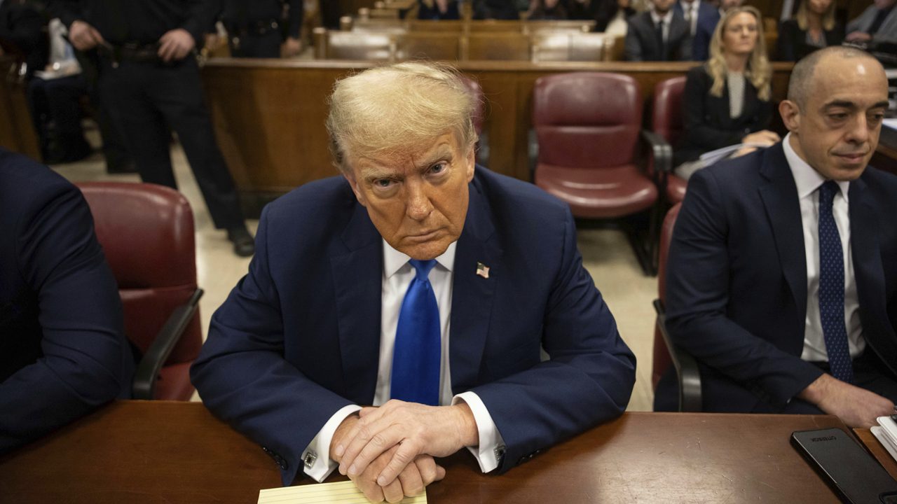 Former president Donald Trump, center, awaits the start of proceedings at Manhattan criminal court, Monday, April 22, 2024, in New York. Opening statements in Donald Trump's historic hush money trial are set to begin. Trump is accused of falsifying internal business records as part of an alleged scheme to bury stories he thought might hurt his presidential campaign in 2016. (AP Photo/Yuki Iwamura, Pool)